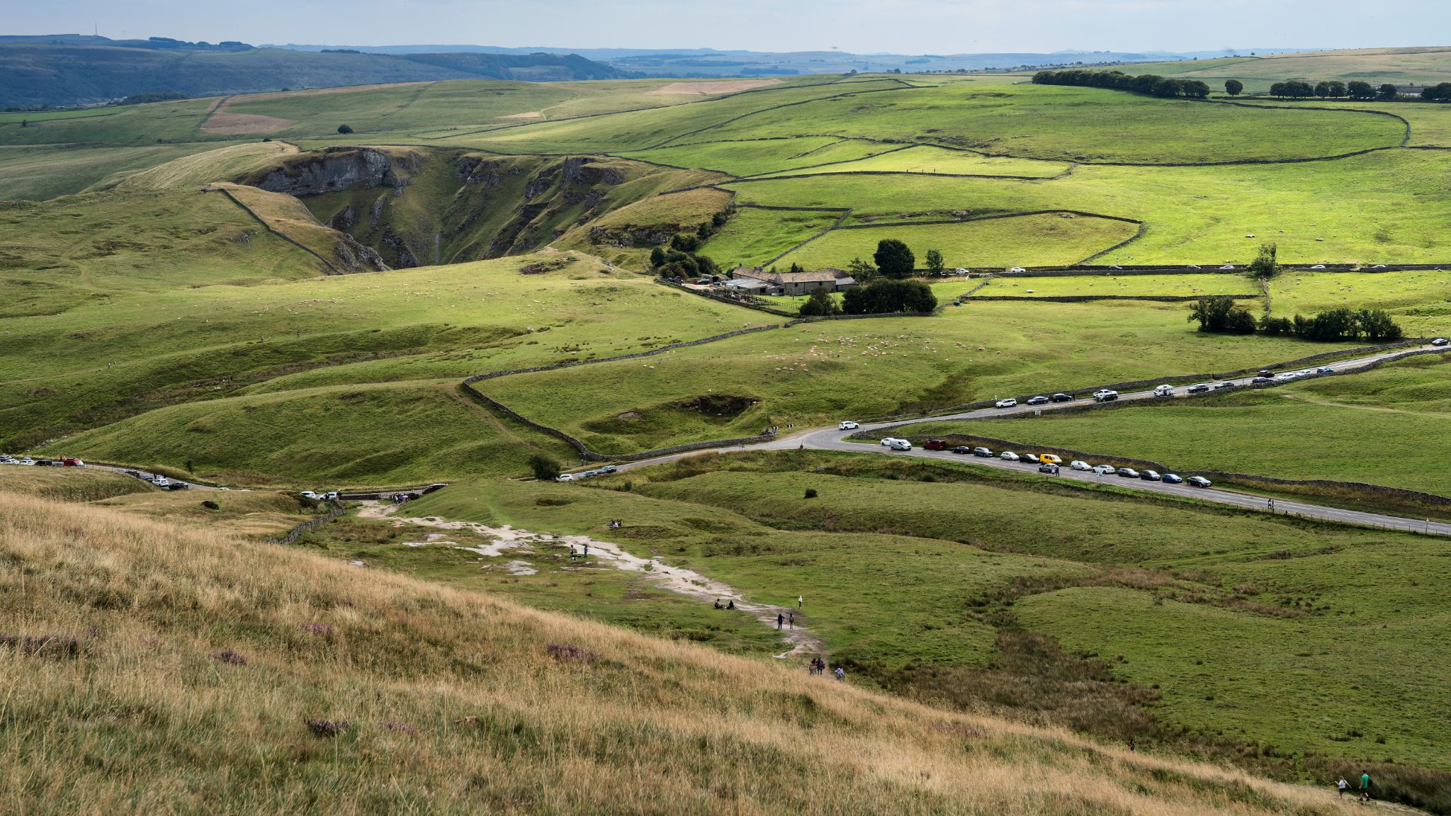 Vom Mam-Tor-Gipfel eröffnet sich eine der eindrucksvollsten Fernsichten des Peak District, über das Edale Valley bis zum Great Ridge bis nach Lose Hill. Mam Tor ist für Erdrutsche an seiner Ostflanke bekannt, weshalb 1979 ein Abschnitt der A625 aufgegeben wurde. Die zerstörte Straße bleibt heute ein faszinierbares Mahnmal für den Kampf zwischen Mensch und Natur.